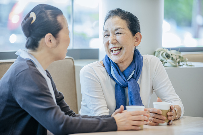 Senior Asian women enjoying a coffee in a cafe in Tokyo, Japan. japanese female sharing a joke with a friend.