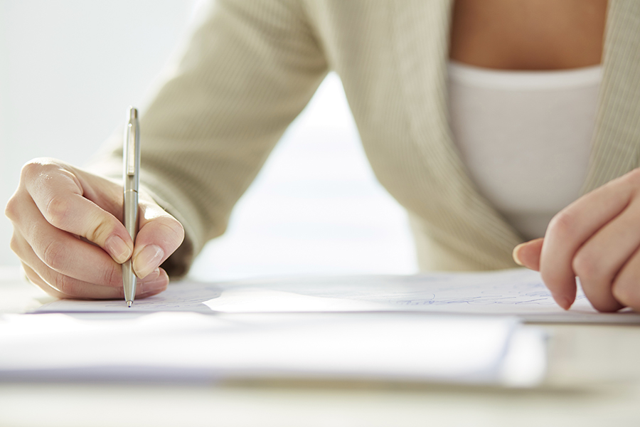 Hand of businesswoman writing with pen